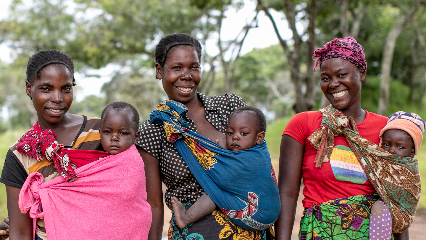 Tre kvinner som står med tre barn