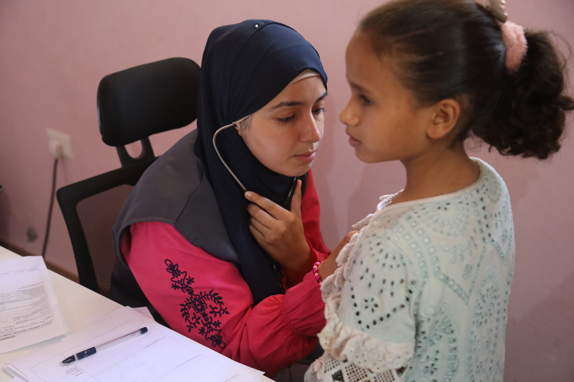 Sykepleier tar helsekontroll på en jente