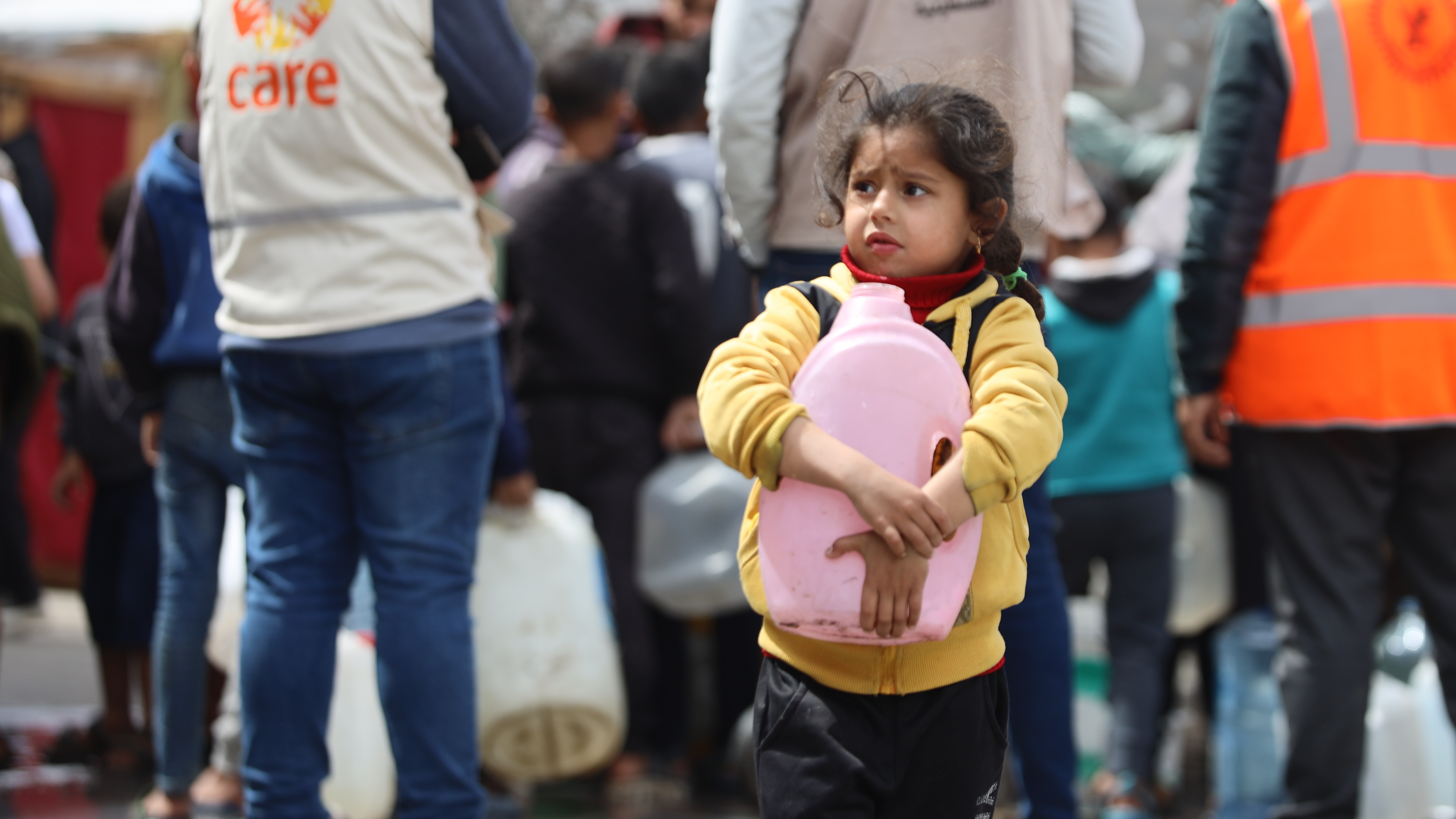 Bilde av en liten jente som har fått vann utdelt fra CARE i Gaza